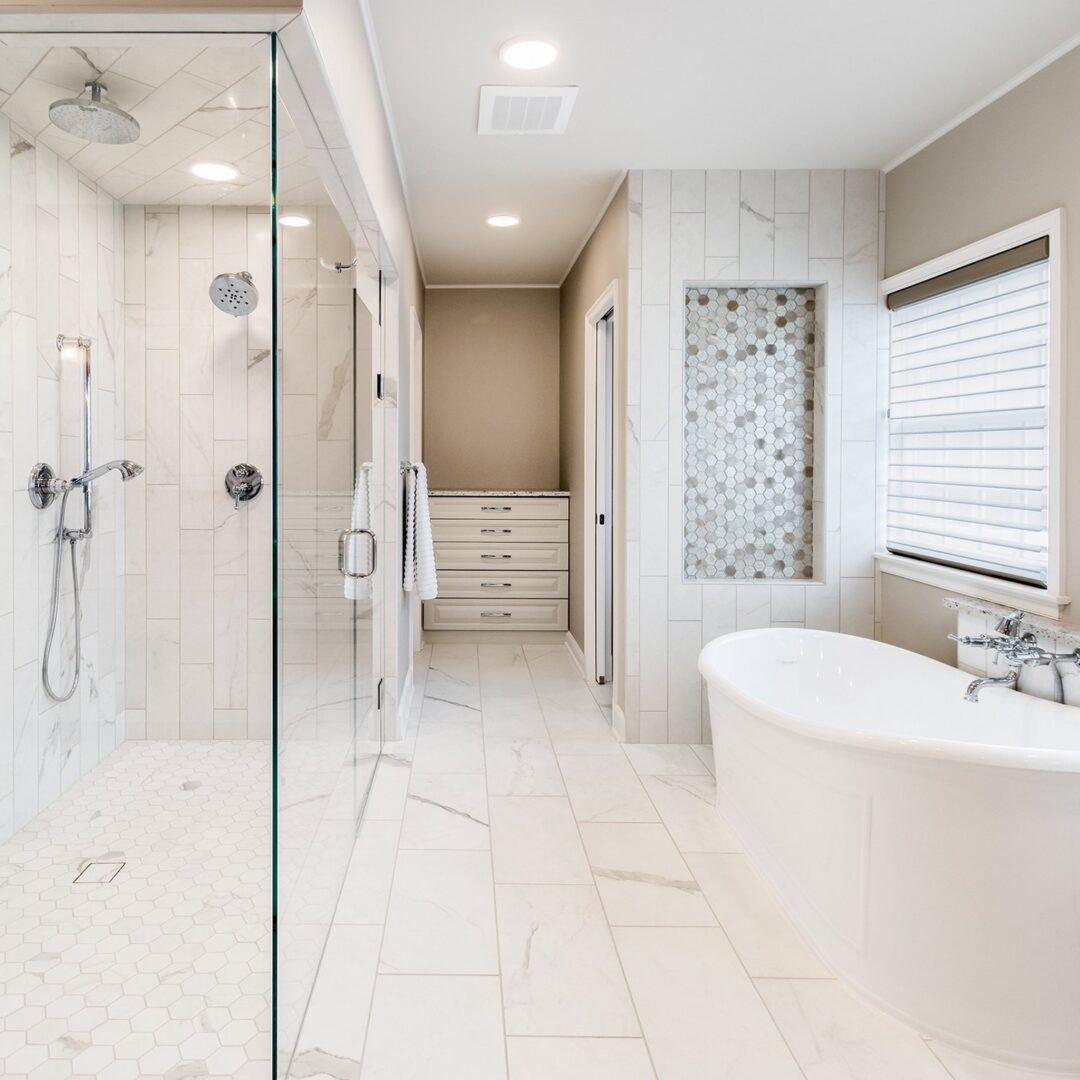 A large bathroom with a walk in shower and a tub.