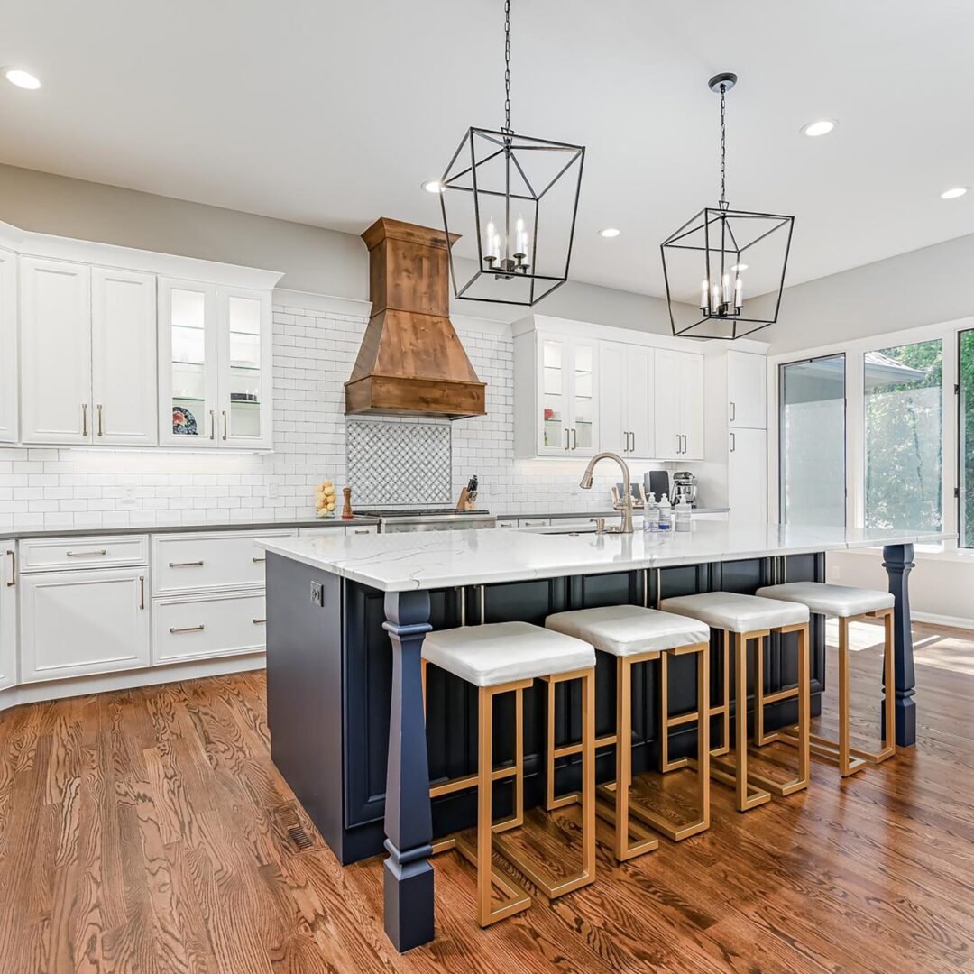 A kitchen with white cabinets and wooden floors
