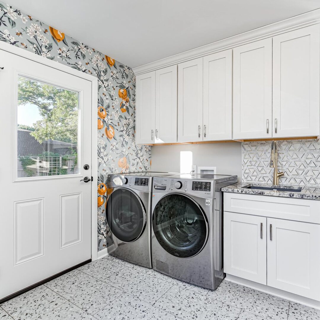 A laundry room with two machines and a sink